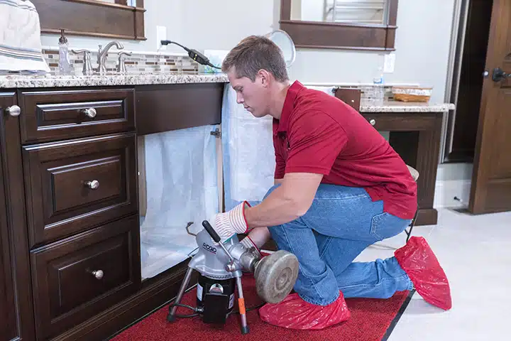 Reid & Pederson technician working on drain in Crete, IL.